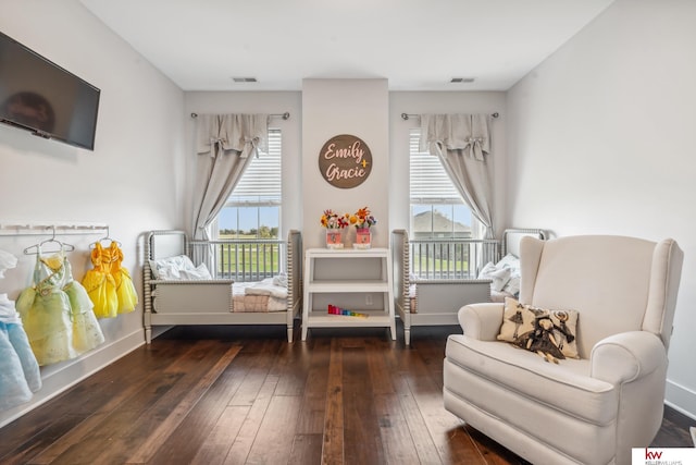 sitting room featuring dark wood-type flooring and a wealth of natural light