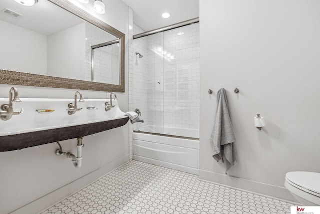 bathroom featuring toilet and enclosed tub / shower combo