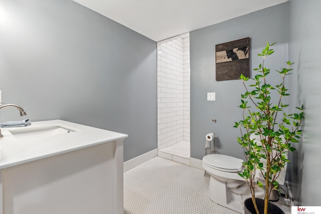 bathroom featuring vanity, toilet, a shower, and tile patterned flooring