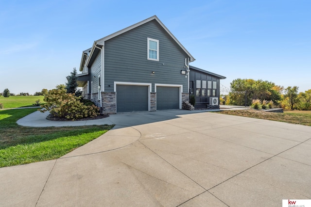 view of side of home featuring a garage and a lawn