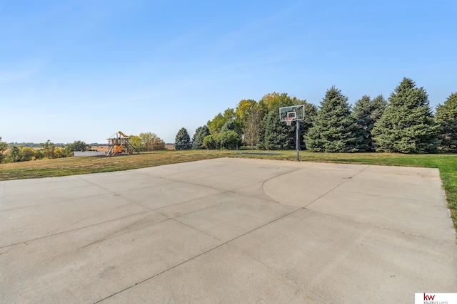 view of basketball court with a lawn and a playground