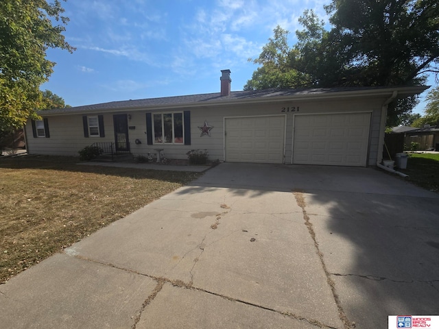 ranch-style home with a garage and a front lawn