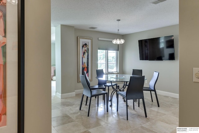 dining room featuring an inviting chandelier and a textured ceiling