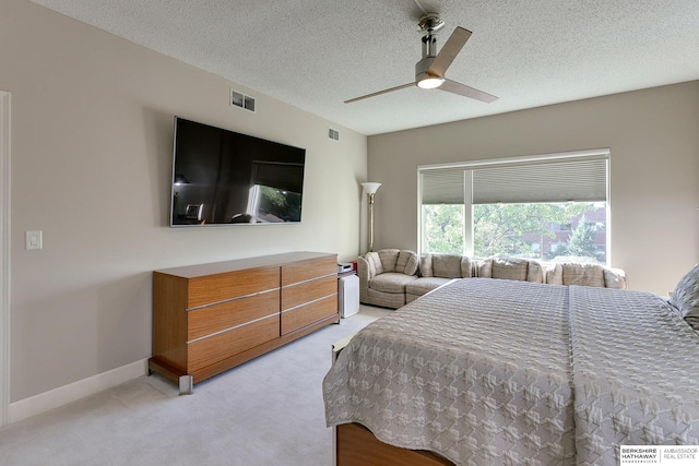 carpeted bedroom with ceiling fan and a textured ceiling