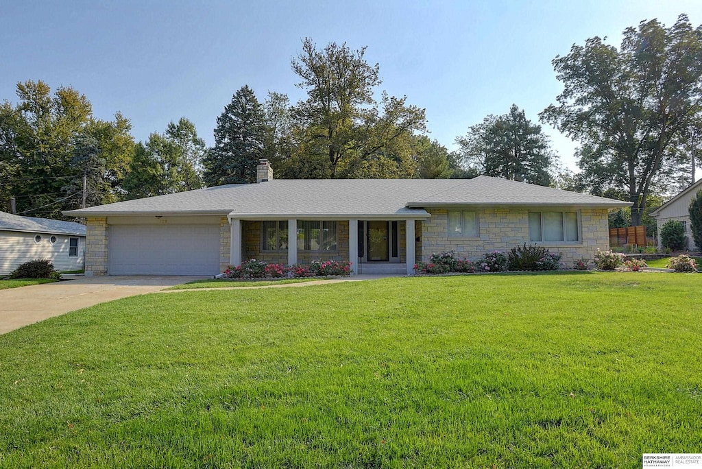 ranch-style house with a garage and a front yard