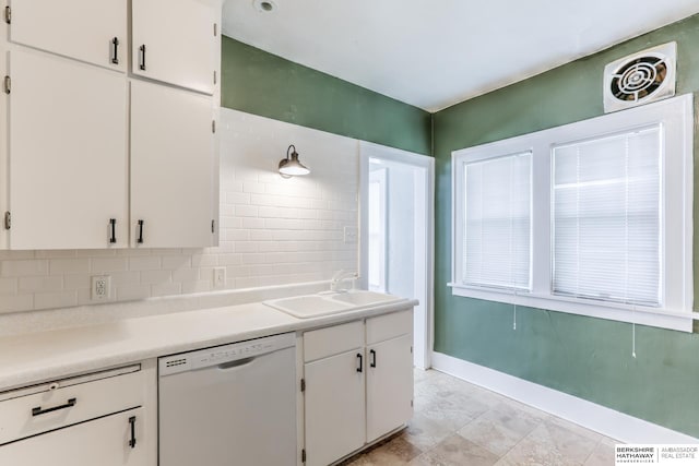 kitchen featuring white dishwasher, white cabinetry, sink, and tasteful backsplash