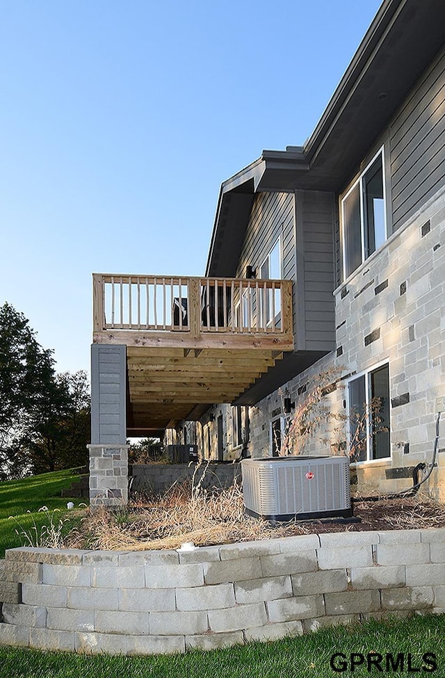 view of property exterior with a wooden deck and central AC unit