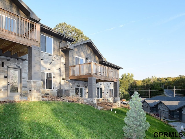 back of property featuring a balcony and a yard