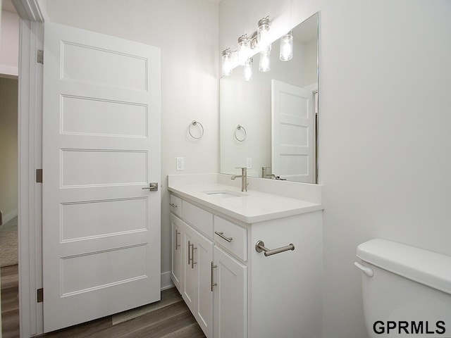 bathroom featuring hardwood / wood-style flooring, vanity, and toilet