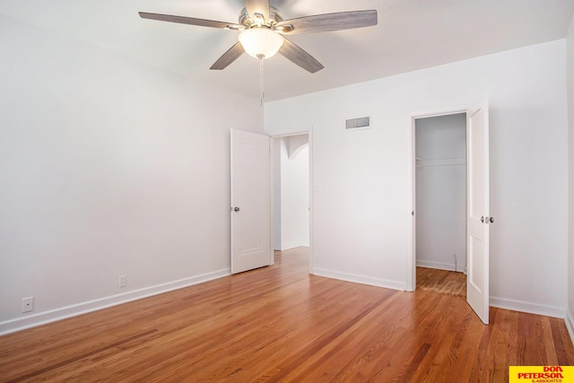 unfurnished bedroom featuring ceiling fan, a closet, and hardwood / wood-style floors