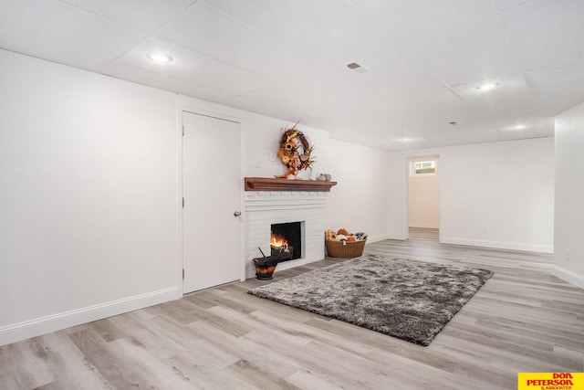 living room featuring light wood-type flooring and a fireplace