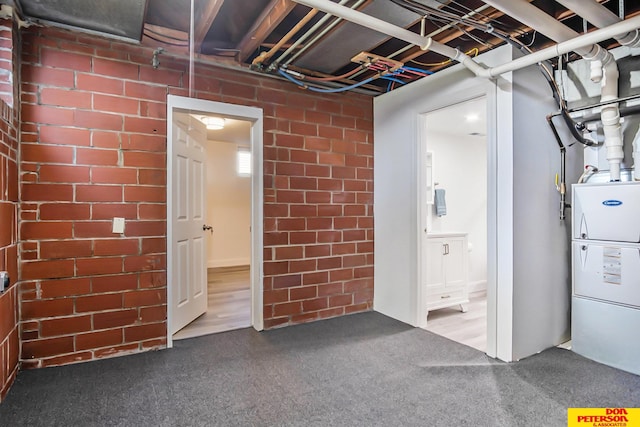 basement featuring brick wall and hardwood / wood-style flooring