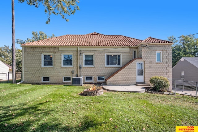 rear view of property with a fire pit, central AC, a lawn, and a patio area