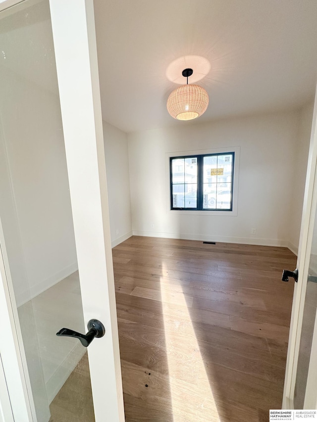 spare room with wood-type flooring