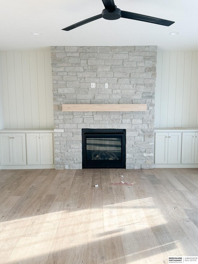 interior details featuring ceiling fan, hardwood / wood-style floors, and a fireplace