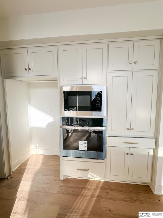 kitchen with light wood-type flooring and appliances with stainless steel finishes