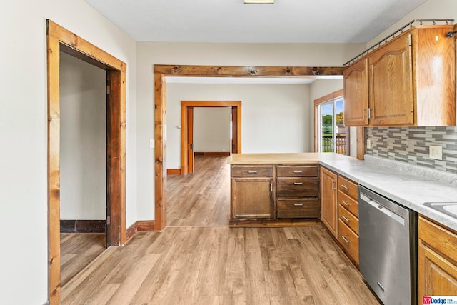 kitchen with light hardwood / wood-style flooring, backsplash, and stainless steel dishwasher