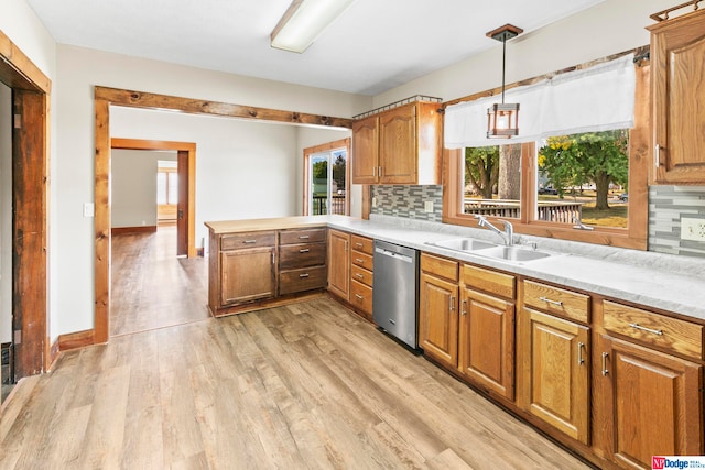 kitchen featuring dishwasher, backsplash, decorative light fixtures, and sink