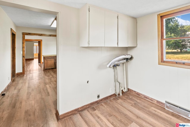 washroom featuring light hardwood / wood-style floors, hookup for an electric dryer, cabinets, and a textured ceiling