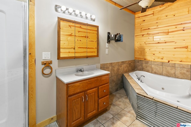 bathroom with ceiling fan, a relaxing tiled tub, tile patterned flooring, and vanity