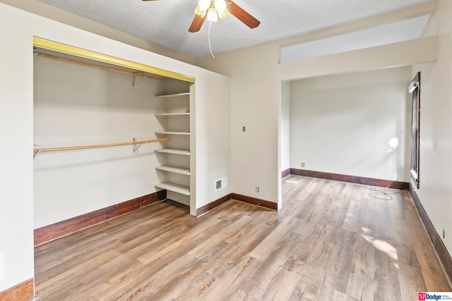 interior space with ceiling fan, a closet, and wood-type flooring