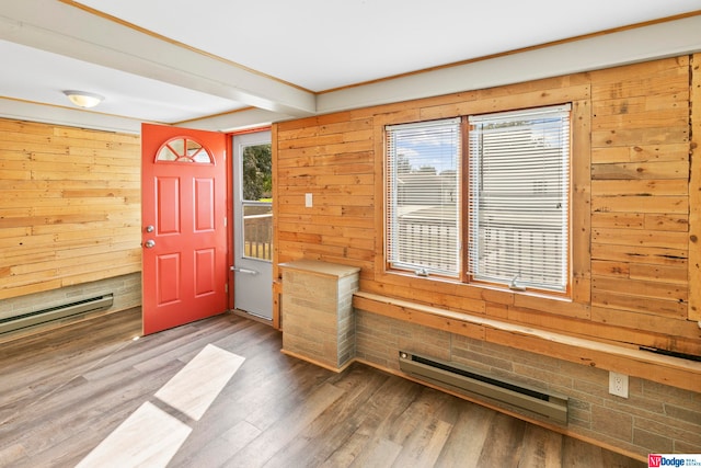 entrance foyer featuring hardwood / wood-style flooring, wooden walls, and a baseboard heating unit