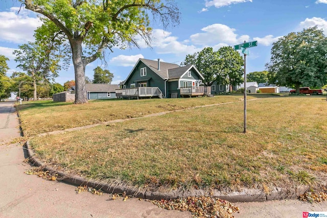 view of front facade with a front yard and a wooden deck