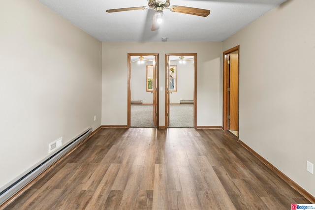 spare room with ceiling fan, a textured ceiling, dark hardwood / wood-style floors, and a baseboard heating unit