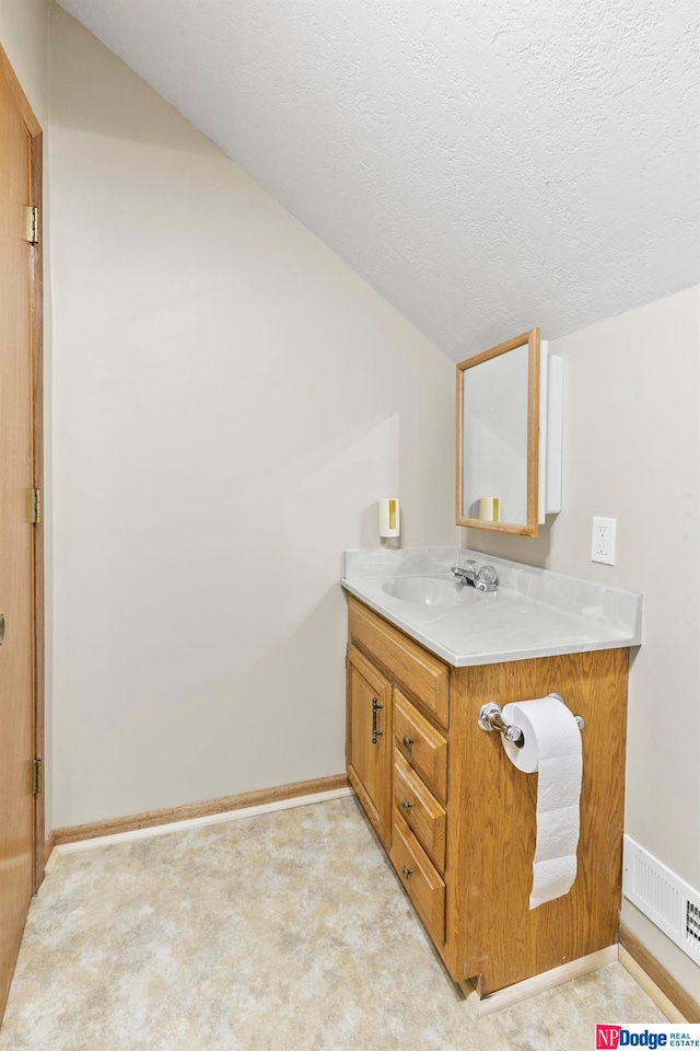 bathroom with vanity and a textured ceiling