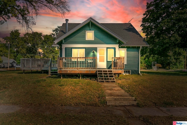 view of front facade with a yard and a wooden deck