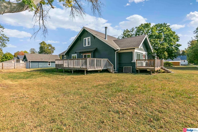 back of property with a deck and a yard