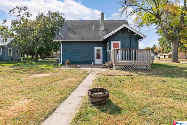 rear view of property with a yard and a deck