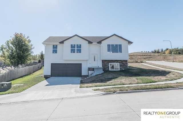 raised ranch with a garage and a front lawn