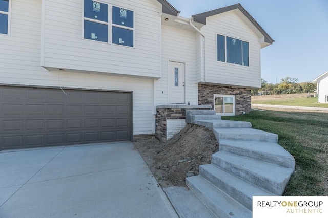 raised ranch featuring a garage and a front yard