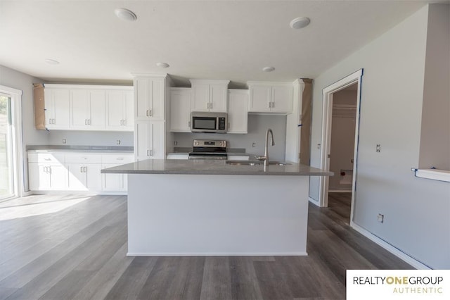 kitchen featuring a center island with sink, white cabinetry, hardwood / wood-style floors, and stainless steel appliances