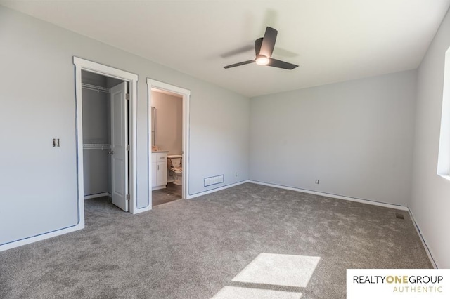 unfurnished bedroom with carpet floors, ceiling fan, a spacious closet, a closet, and connected bathroom