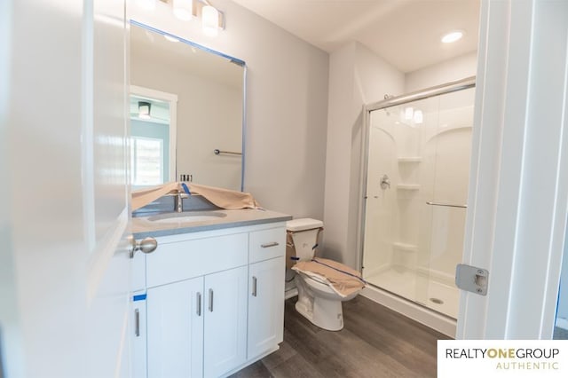 bathroom featuring an enclosed shower, hardwood / wood-style floors, vanity, and toilet