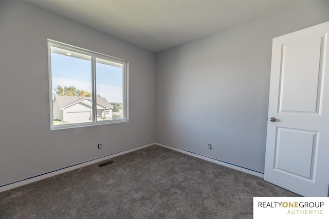 unfurnished room with dark carpet