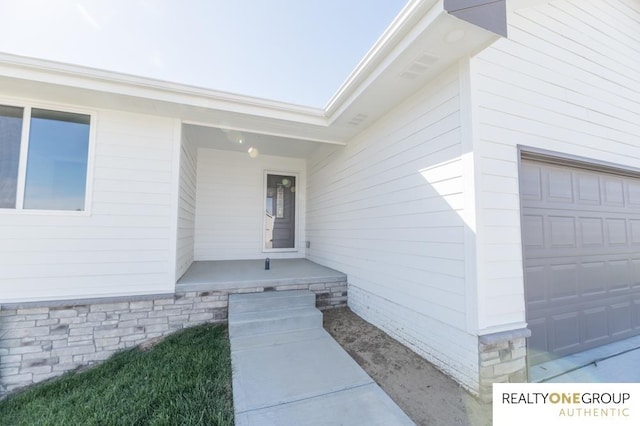 doorway to property with a garage