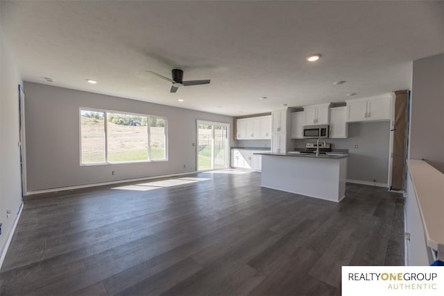 kitchen featuring a center island with sink, dark wood-type flooring, ceiling fan, and white cabinetry