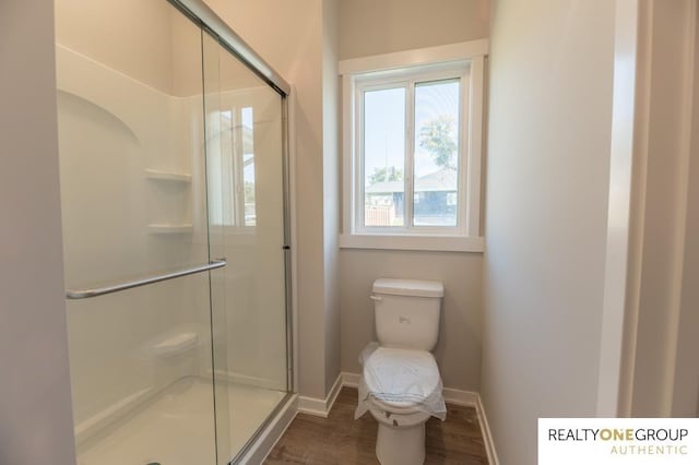 bathroom featuring an enclosed shower, hardwood / wood-style floors, and toilet