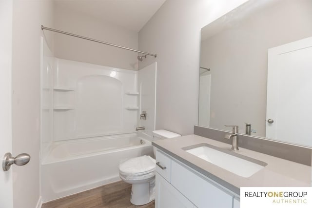 full bathroom with hardwood / wood-style flooring, vanity, washtub / shower combination, and toilet