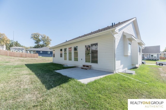 rear view of property with a yard and a patio