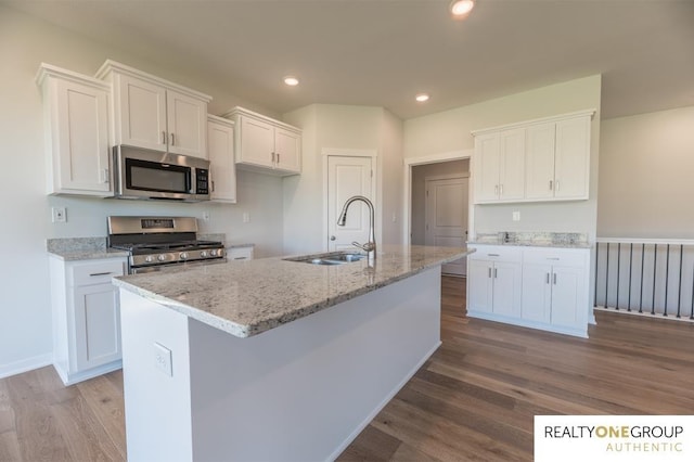 kitchen featuring appliances with stainless steel finishes, a center island with sink, sink, and white cabinets