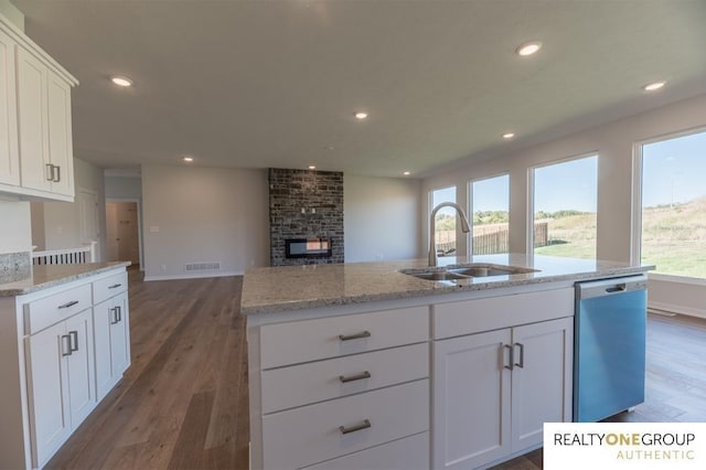 kitchen with open floor plan, a sink, wood finished floors, and dishwashing machine