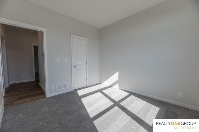 unfurnished bedroom featuring a closet and dark hardwood / wood-style flooring