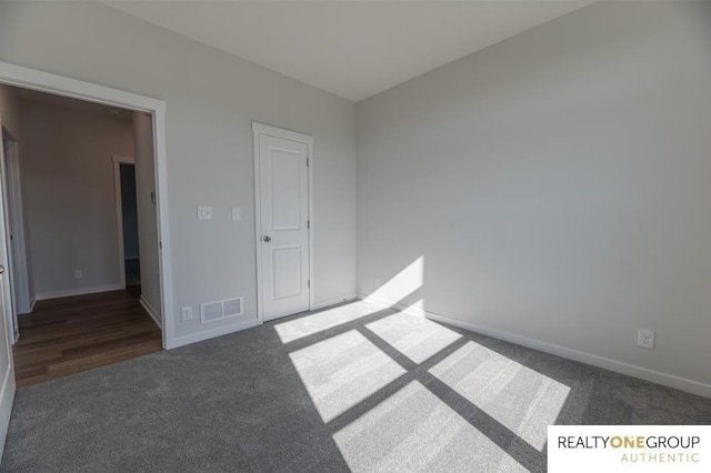 unfurnished bedroom featuring baseboards, visible vents, and carpet