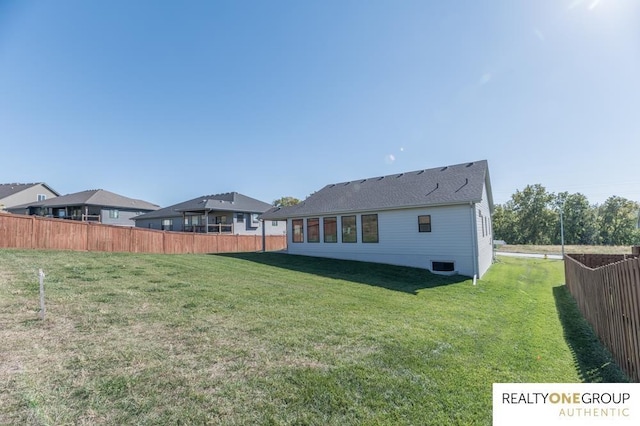 rear view of house featuring a lawn, central AC, and fence