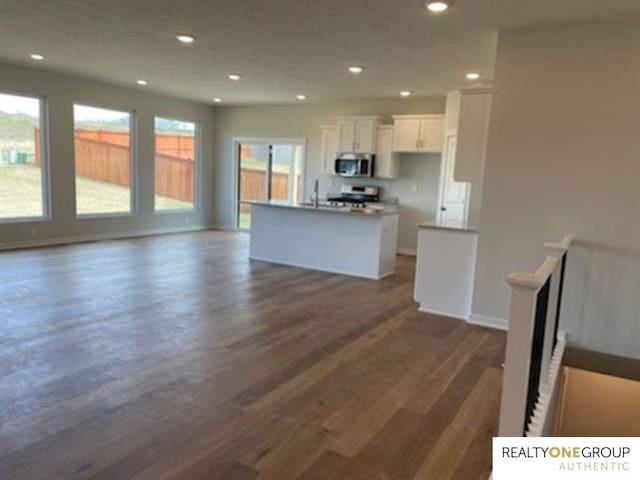 kitchen featuring white cabinets, a kitchen island with sink, dark hardwood / wood-style flooring, and stainless steel appliances