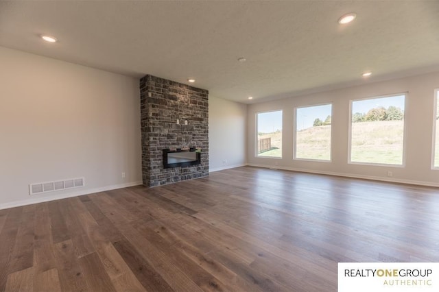 unfurnished living room featuring visible vents, wood finished floors, a large fireplace, and recessed lighting